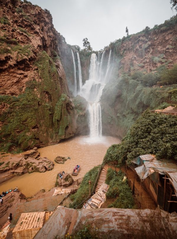 a group of people standing in front of a waterfall